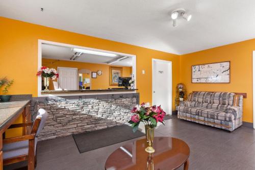 a living room with a couch and a table at Budget Host Inn by Hotel O Portland near I-65 in Portland