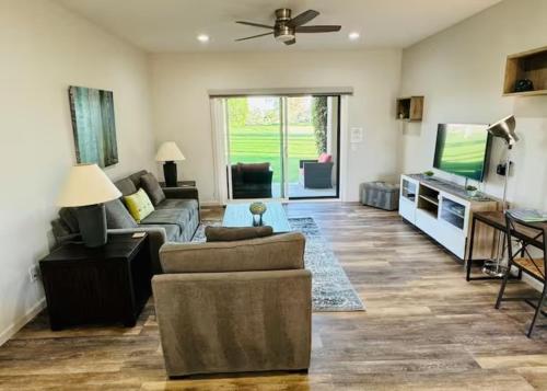 a living room with a couch and a tv at Desert Princess Serenity Suite in Cathedral City