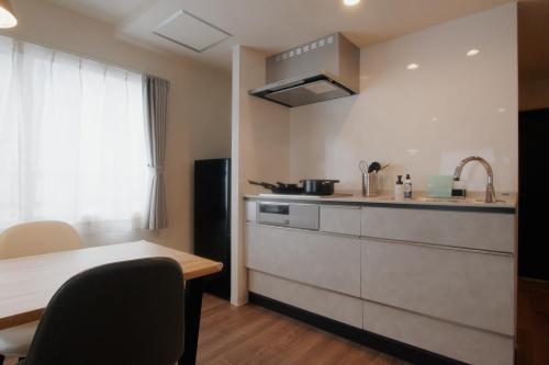 a kitchen with a counter and a table and a sink at LikeINN札幌スイーズS4 in Sapporo
