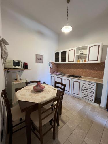 una cucina con un tavolo e sedie in una stanza di Casa La Pavoncella a Orosei