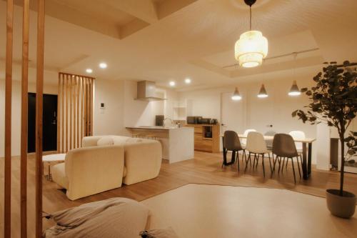 a living room and kitchen with a couch and a table at LikeINN札幌スイーズS4 in Sapporo