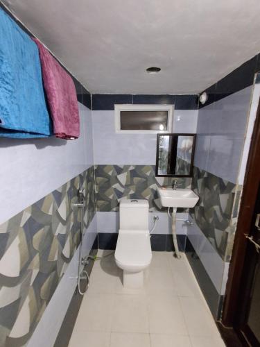 a bathroom with a toilet and a sink at Gitanjali Homestay by Lake Pichola Udaipur in Udaipur