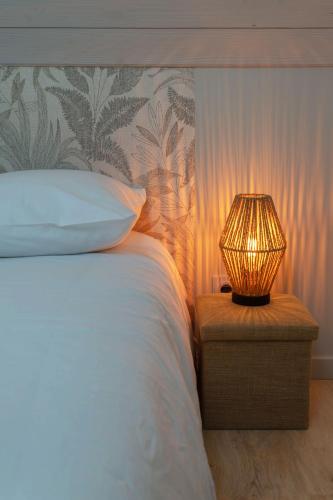 a bed with a lamp on a table next to it at Maison Billy - Maison design et climatisée avec jardin in Billy
