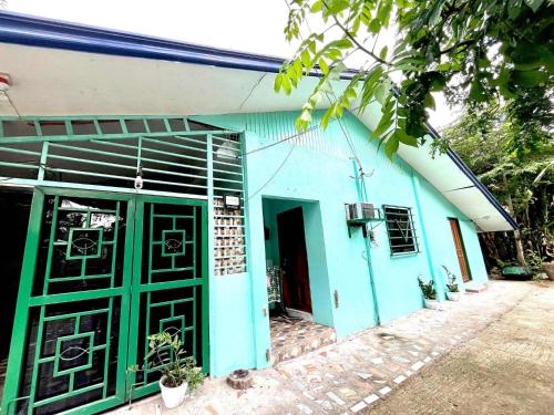 a blue building with green doors in front of it at Cebu - Victoria's Guest House in Badian