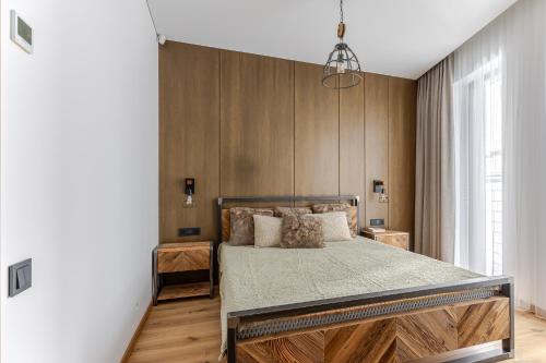 a bedroom with a bed and wooden walls at Luxury apartment in the city center Nr3 in Kaunas
