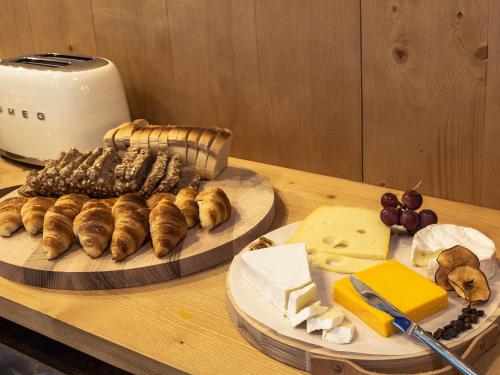 einen Tisch mit Speisen und Käse in der Unterkunft Armazém Luxury Housing- Architectural & Design Hotel in Porto