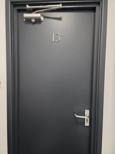 a black door with the number on it at Cosy Studio City Centre in Wolverhampton