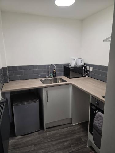 a kitchen with a sink and a counter top at Cosy Studio City Centre in Wolverhampton