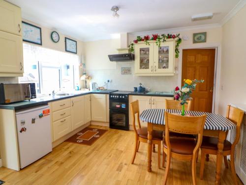 a kitchen with a table and some chairs and a kitchen with a table at Waterfall House in Ardcahan Bridge