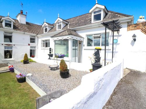 a white house with a fence in front of it at Waterfall House in Ardcahan Bridge