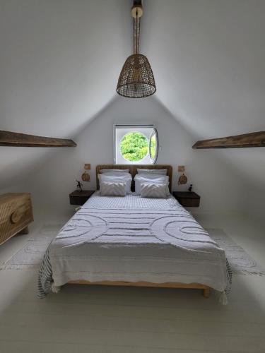 a bedroom with a large bed with a window at La petite maison blanche in Dunkerque