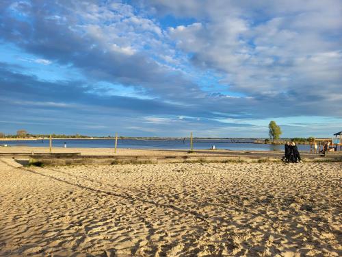 a group of people walking on the beach at Chalet Meerwijck mit Terrasse am Wasser und Meer mit Schwimmbad in Kropswolde