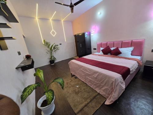 a bedroom with a large bed with a pink headboard at Varanasi Soulscape -Tajside Retreat in Varanasi