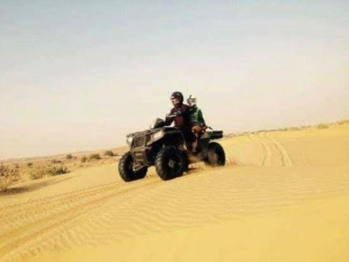 two people riding on a four wheeler in the desert at Sam Desert Luxury Resort in Sām
