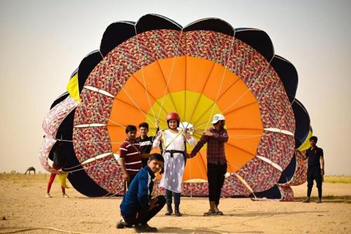 a group of people standing in front of a large kite at Sam Desert Luxury Resort in Sām