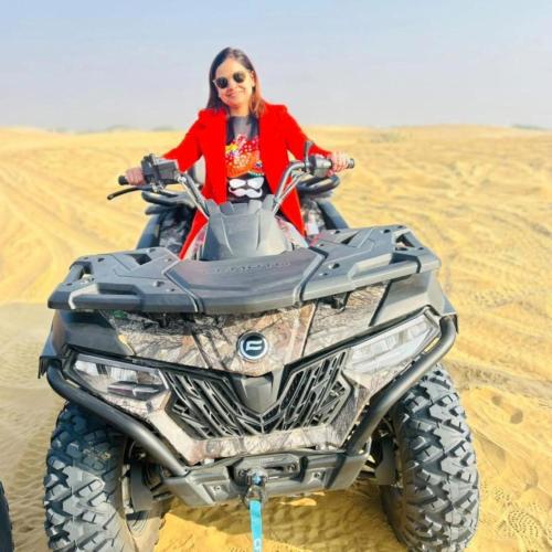 a woman riding a quad bike in the desert at Sam Desert Luxury Resort in Sām