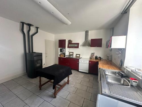 a kitchen with a stove and a table in it at Le Milpa LXXXVIII in Brouvelieures