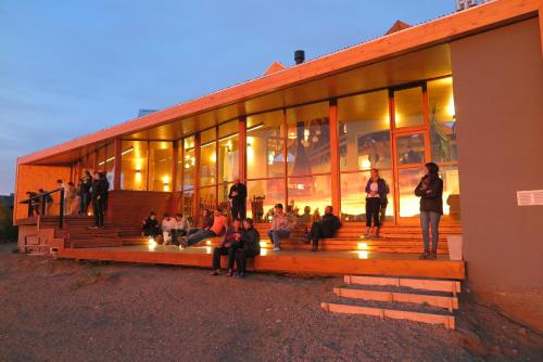 a group of people sitting outside of a building at America Del Sur Calafate Hostel in El Calafate