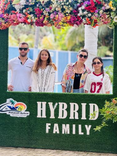 a group of people standing in front of a hyundai family sign at Nilaveli Hybrid Holiday Hotel in Nilaveli
