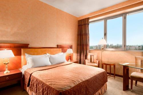a hotel room with a bed and a large window at Ramada Plaza by Wyndham Gence in Ganja