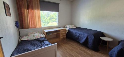 a small room with two beds and a window at House with2 bedroom, bath, sauna, and big yard in Hyvinkää