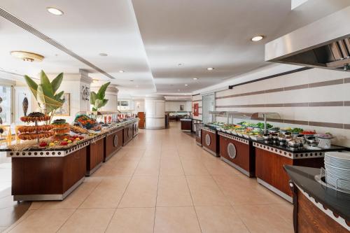 a buffet line in a restaurant with food on display at Hotel Grand Kaptan - Ultra All Inclusive in Alanya