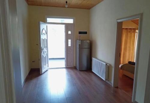 an empty room with a door and a room with a refrigerator at Guest House Artjoni Fierze in Fierzë