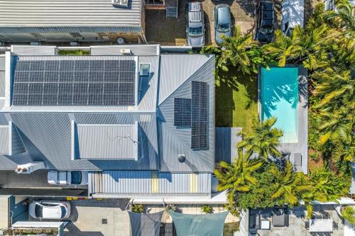 an overhead view of a house with a swimming pool and palm trees at Lady Luxe - Beautiful spacious pet friendly home near the ocean in Byron Bay