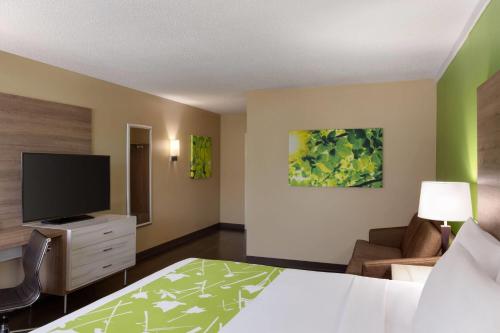 a hotel room with a bed and a flat screen tv at Wyndham Garden Washington DC North in Washington