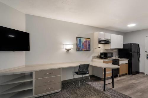 an office with a desk and a kitchen with a refrigerator at MainStay Suites Denver Tech Center in Centennial