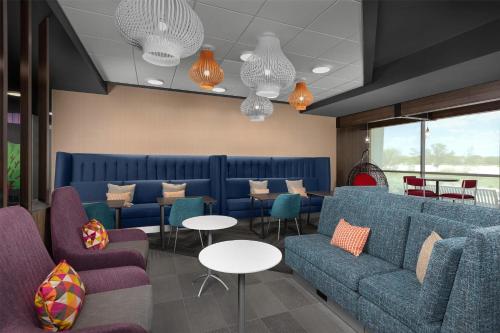 a waiting room with blue couches and tables at Tru By Hilton Joliet Plainfield in Joliet