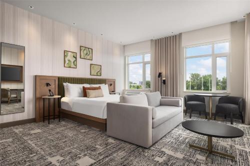 モントリオールにあるHotel Railwayparc Montreal, Tapestry Collection By Hiltonのベッドとソファとテーブルのある寝室