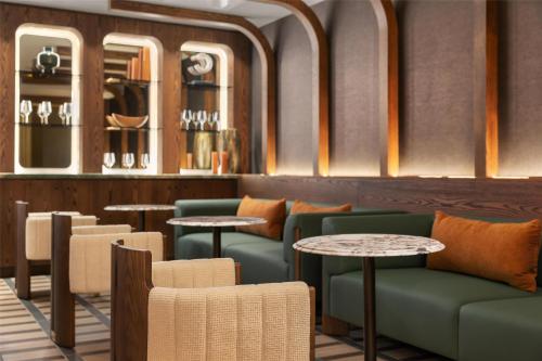 a restaurant with green chairs and tables and mirrors at Hotel Railwayparc Montreal, Tapestry Collection By Hilton in Montréal