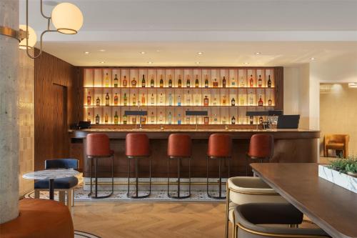 a bar in a restaurant with brown stools at Hotel Railwayparc Montreal, Tapestry Collection By Hilton in Montréal