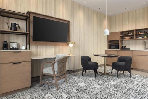 a hotel room with a tv and a table and chairs at Hotel Railwayparc Montreal, Tapestry Collection By Hilton in Montréal