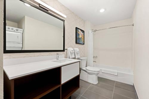 a bathroom with a sink and a toilet and a mirror at Everhome Suites Huntsville - Research Park in Huntsville