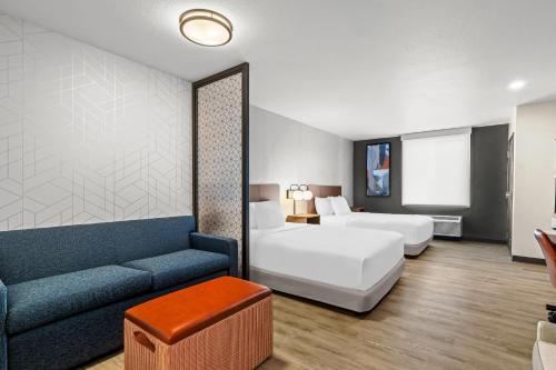 a hotel room with a bed and a couch at Everhome Suites Temecula in Temecula
