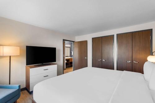 a bedroom with a bed and a flat screen tv at Everhome Suites Bastrop in Bastrop