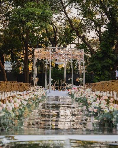 an aisle with a white altar and flowers at The Pamodzi Hotel in Lusaka