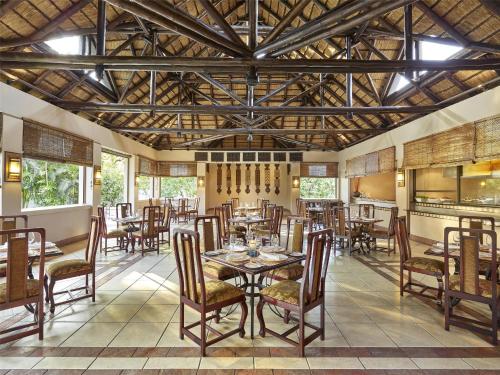 a dining room with tables and chairs and a ceiling at The Pamodzi Hotel in Lusaka