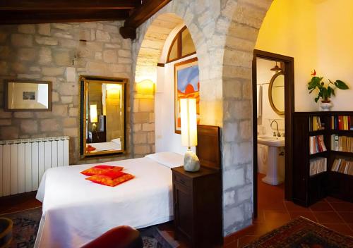 a bedroom with a white bed and a mirror at B&B Villa Miramì in Saturnia