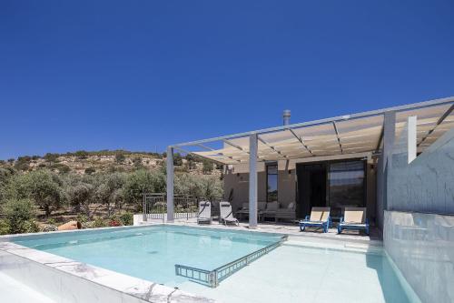 a swimming pool with two chairs and a house at Villa Me - With Private Pool in Roumelí