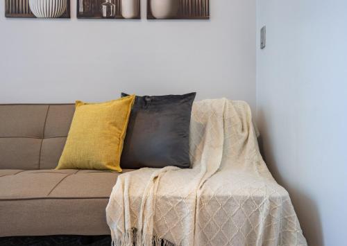 a couch with a blanket on it in a living room at Virgo Nest Rentals - 38th Park Ave, IT Park Cebu City View in Cebu City