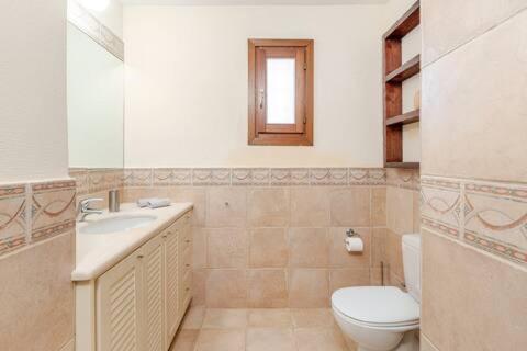 a white bathroom with a toilet and a sink at Marilia VIllage Spathi Kea "Villa Helios" in Spathi 