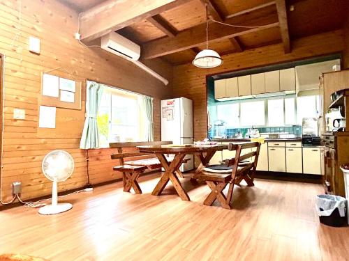 南小国町Whole house rental 天然温泉付きコテージRAI駐車場付き黒川温泉街まで車で5分的房间里有一张桌子和几把椅子的厨房