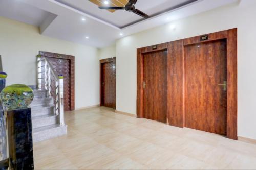 an empty room with wooden doors and stairs at Hotel The Sangat Prime 