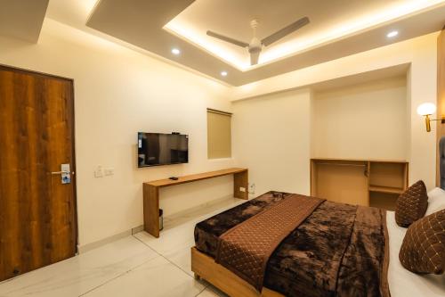 a bedroom with a bed and a flat screen tv at Hotel Park Hills in Mohali