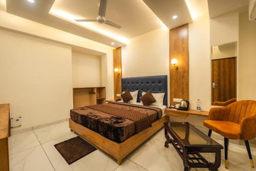 a bedroom with a bed and a desk and a chair at Hotel Park Hills in Mohali
