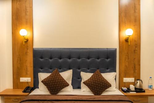 a bed with a black headboard and two pillows at Hotel Park Hills in Mohali