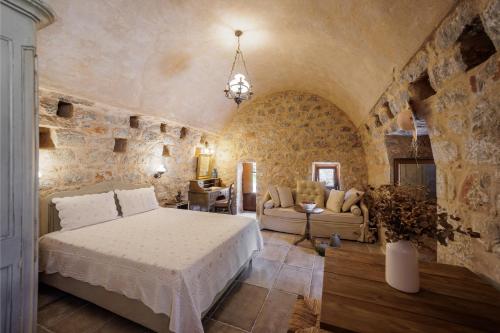 a bedroom with a bed and a stone wall at Arapakis Historic Castle in Pirgos Dhirou
